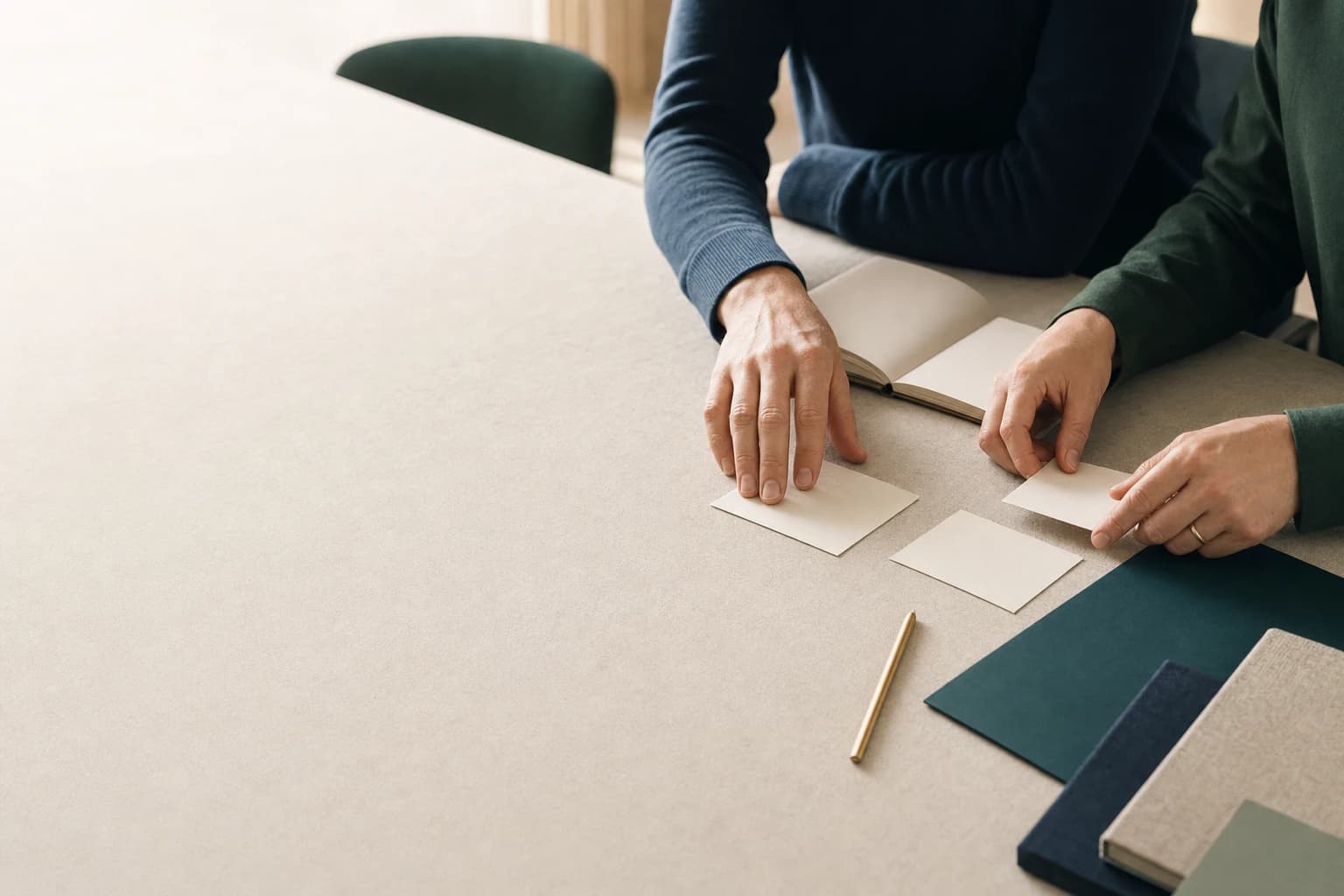 Zwei Personen ordnen Unterlagen und Notizen auf einem Workshop-Tisch.